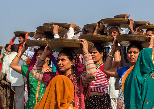 women carrying trays overhead (india), carrying on the head, clay, crowd, hindu ceremony, hindu pilgrimage, hinduism, indian women, kumbh mela, lingams, offerings, shiva linga, shiva lingam, shivling, trays, walking