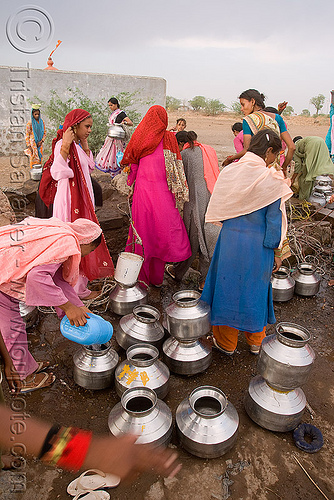 women with metal water jars near water well - ajanta (india), ajanta, communal water well, crowd, drought, metal jars, pulling water, villagers, water jars, women