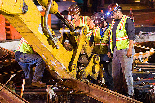 workers adjusting new track rail segment, high-visibility jacket, high-visibility vest, hydraulic arm, light rail, men, muni, ntk, railroad construction, railroad tracks, railway tracks, reflective jacket, reflective vest, safety helmet, safety vest, san francisco municipal railway, track maintenance, track work, workers, working