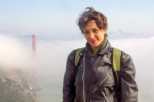 yassmine wearing a leather motorcycle jacket (san francisco), fog, golden gate bridge, leather jacket, motorcycle jacket, suspension bridge, woman, yassmine