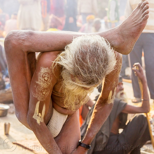 yogi sadhu in yoga position standing with leg behind the head (nepal), baba, beard, contortionist, hindu, hinduism, kathmandu, maha shivaratri, man, pashupatinath, sadhu, stretching, tilak, tilaka, yoga, yogi