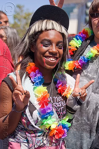 black teen girl at the san francisco gay pride, black woman, flower necklace, gay pride festival, girl, peace sign, rainbow colors, rainbow necklace, v sign, victory sign