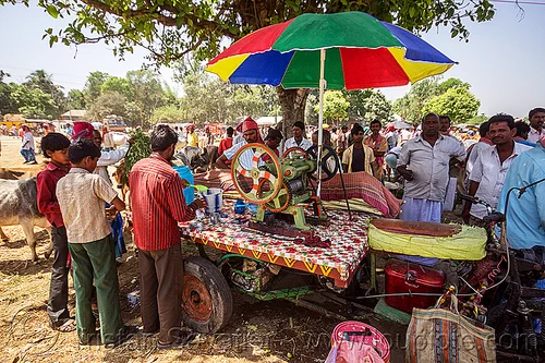 cane juice machine (india), cane juice, crowd, men, press, rainbow colors, stand, street food, street seller, street vendor, sugar cane, trike, umbrella, west bengal