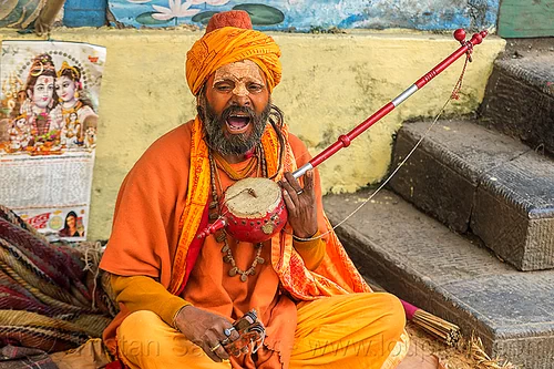 hindu devotee singing mantra and playing musical instrument (nepal), baba, beard, bhagwa, cross-legged, headwear, hindu, hinduism, kathmandu, maha shivaratri, man, musical instrument, pashupatinath, playing music, sadhu, saffron color, singing, sitting, tilak, tilaka