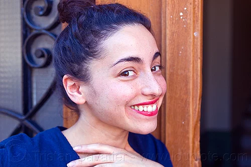 italian girl with playful smile, brunette, curly hair, dilve, door window, house door, ironwork, italian woman, long hair, open door, red lipstick
