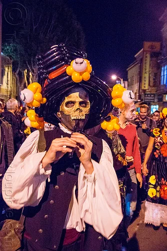 man with skull mask playing flute - dia de los muertos, balloon hat, day of the dead, dia de los muertos, halloween, man, night, party balloons, playing flute, playing music, skull mask