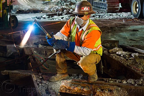 oxy-acetylene torch, blue flame, fire, high-visibility jacket, high-visibility vest, light rail, man, muni, night, ntk, oxy-acetylene cutting torch, oxy-fuel cutting, railroad construction, railroad tracks, railway tracks, reflective jacket, reflective vest, safety helmet, safety vest, san francisco municipal railway, track maintenance, track work, welder, worker, working