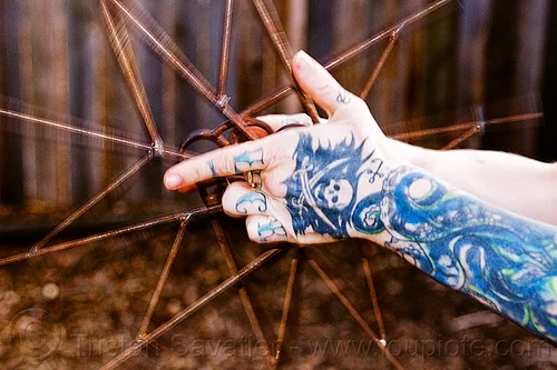 practice with fire fans spinning, arm tattoo, fire fans, hand tattoo, leah, pirate tattoo, skull and sabers tattoo, spinning fans, tattooed, tattoos, woman