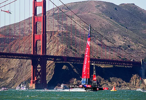 sailing hydrofoil catamaran emirates team new zealand near golden gate bridge, ac72, advertising, america's cup, bay, boat, catamaran, emirates team new zealand, fast, foiling, golden gate bridge, helicopter, hydrofoil catamarans, hydrofoiling, ocean, race, racing, sailboat, sailing hydrofoils, sea, ship, speed, sponsors, suspension bridge