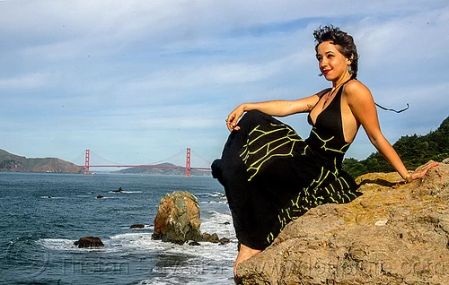 woman in black dress sitting on rock near golden gate bridge, black dress, evening gowns, fashion, golden gate bridge, long dress, ocean, sea, seashore, sitting, suspension bridge, woman, yassmine