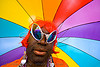 black drag queen with rainbow umbrella, african american man, alien sunglasses, black man, crossdressing, drag queen, earrings, gay pride 2008, gay pride festival, guy, rainbow colors, red wig, transvestite, umbrella